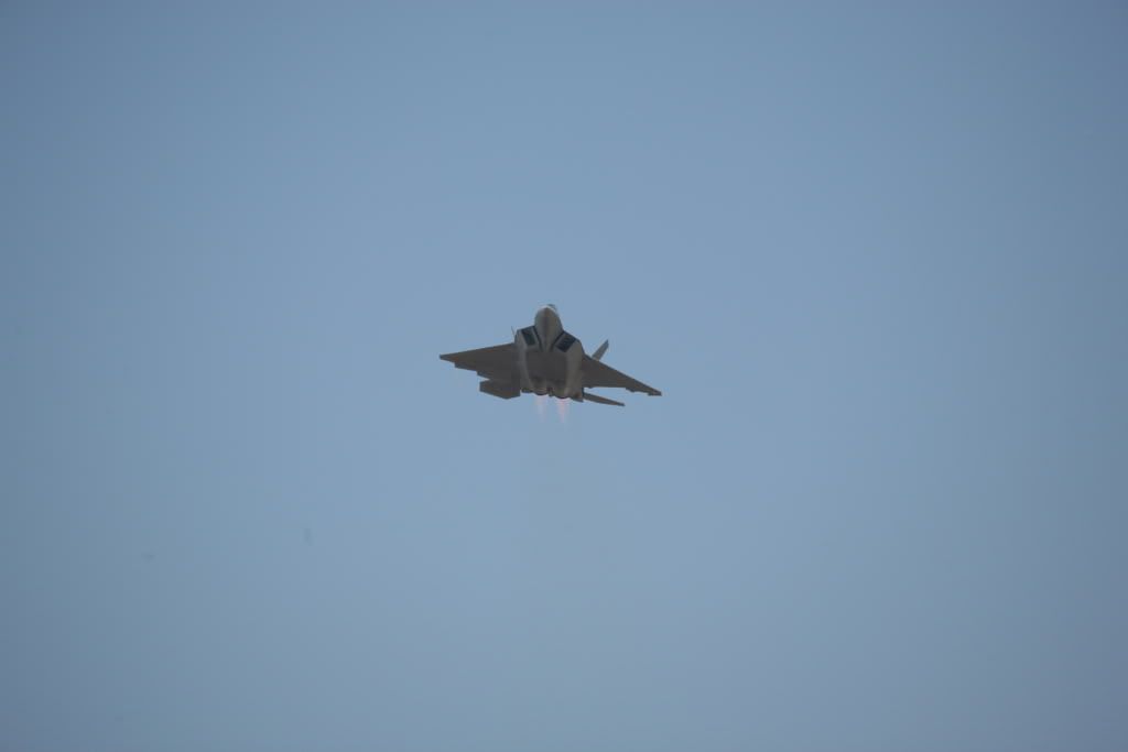 F-22 coming towards us with ailerons and elevators in motion before rolling